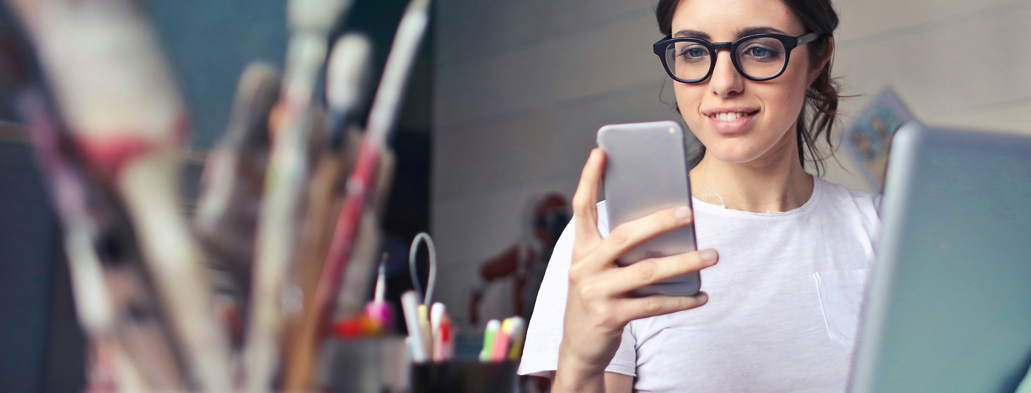 Woman using smartphone and laptop for online banking